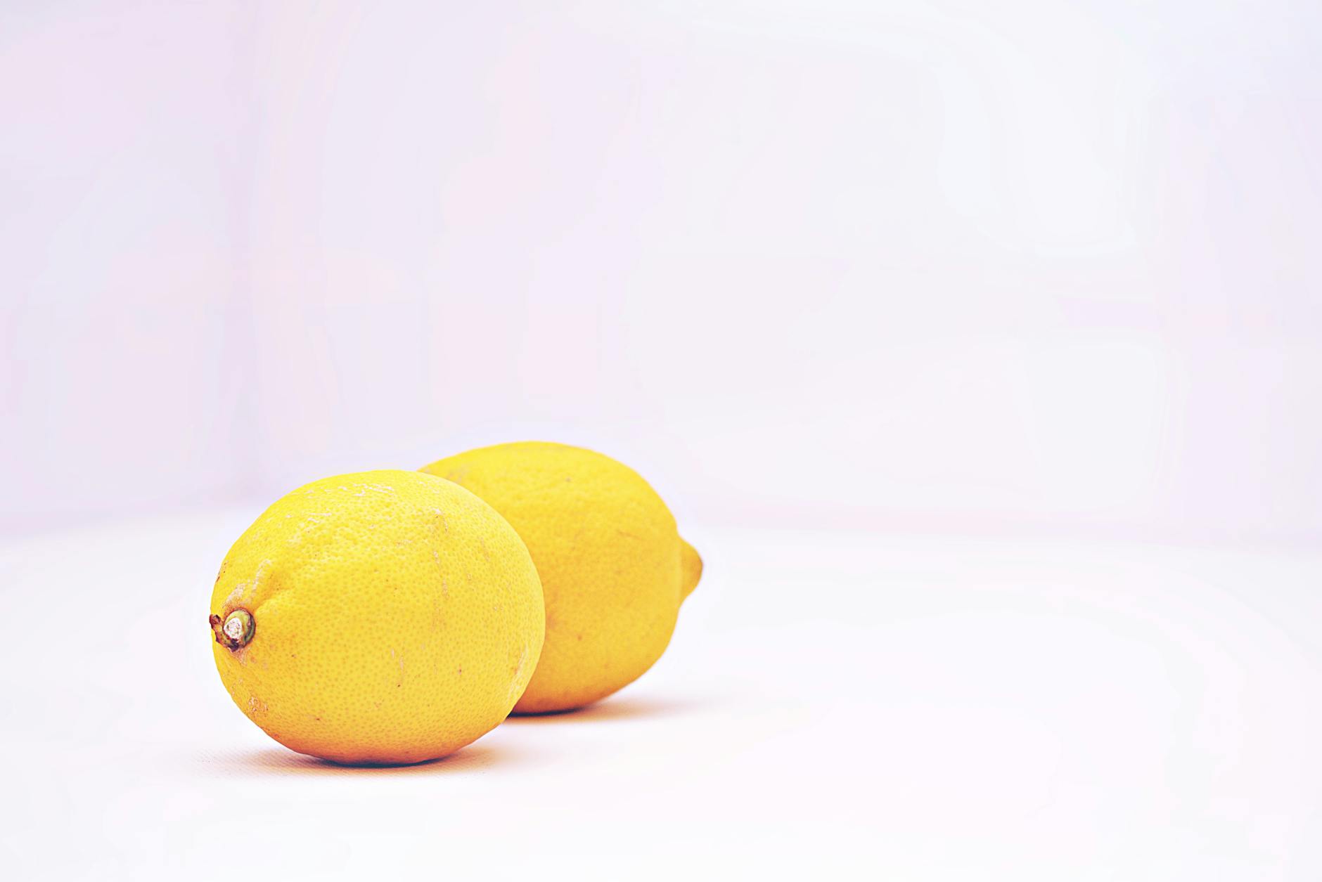 Fresh lemons on a minimalist white background, symbolizing the bright clarity of finding your ideal vibrator intensity