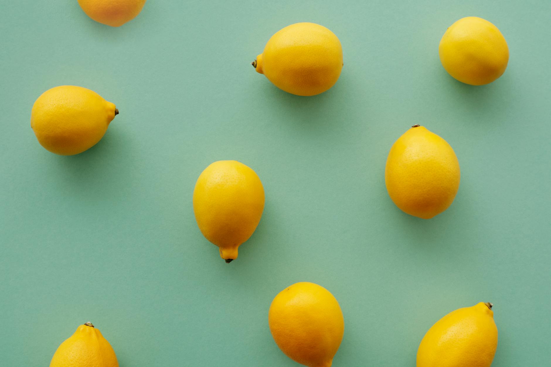 Bright yellow lemons arranged on a pastel background, symbolizing the lemon vibrator and clitoral wellness