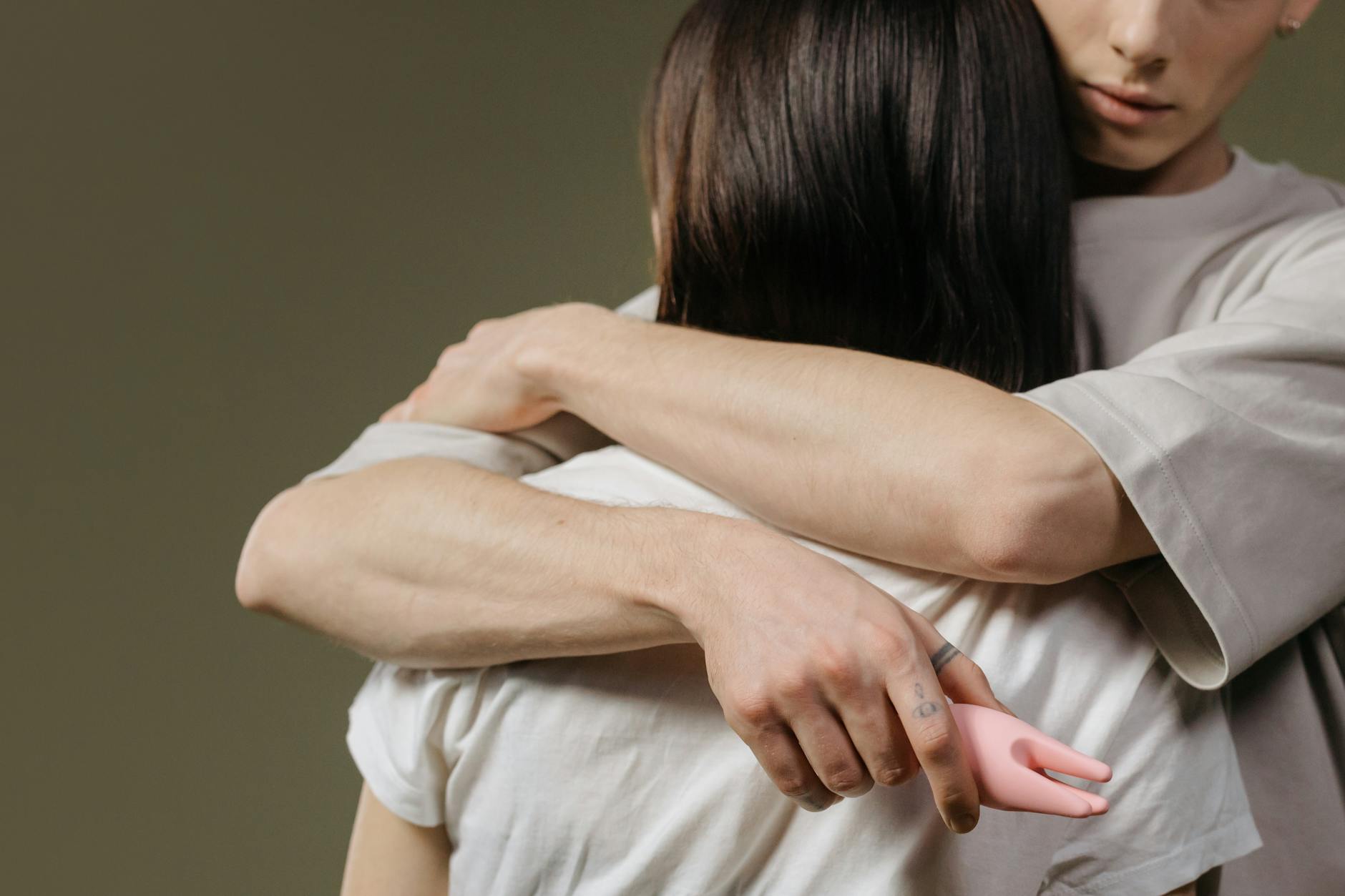 A hand holding a vibrator against a minimalistic purple backdrop, showcasing modern sensuality.